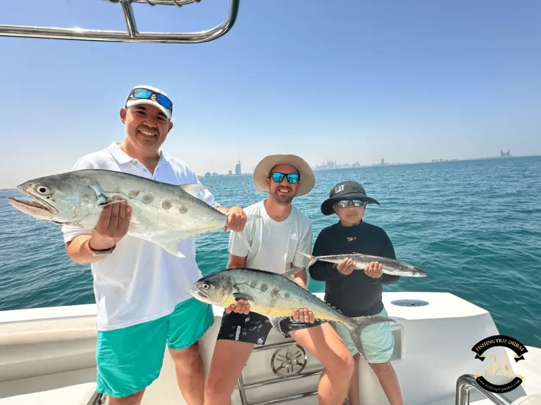 Gallery 7 Three People holding fishes that they caught deep sea in Dubai.