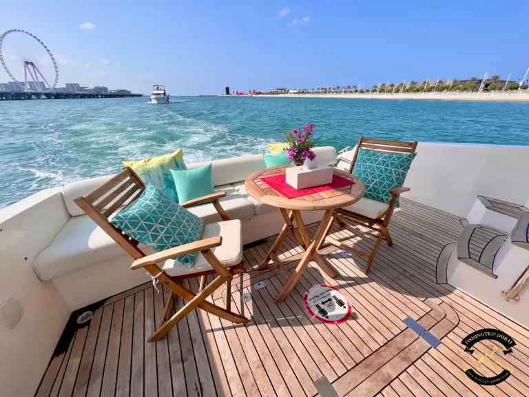 fishing trip Dubai. Majesty 44 ft at the back with chairs and table with dubai eye in view.