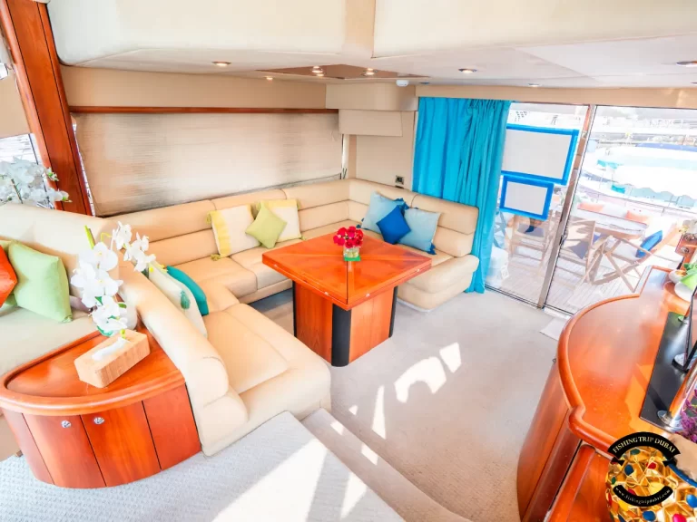 fishing trip Dubai. Sunseeker 70 ft middle interior with U-shaped sofa and table at the center.