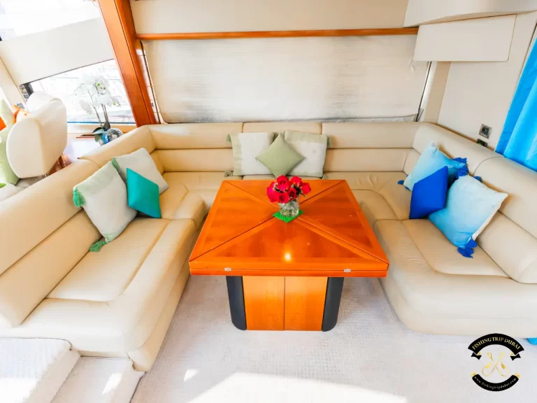 fishing trip Dubai. Sunseeker 70 ft U-shaped sofa with table at the middle interior.